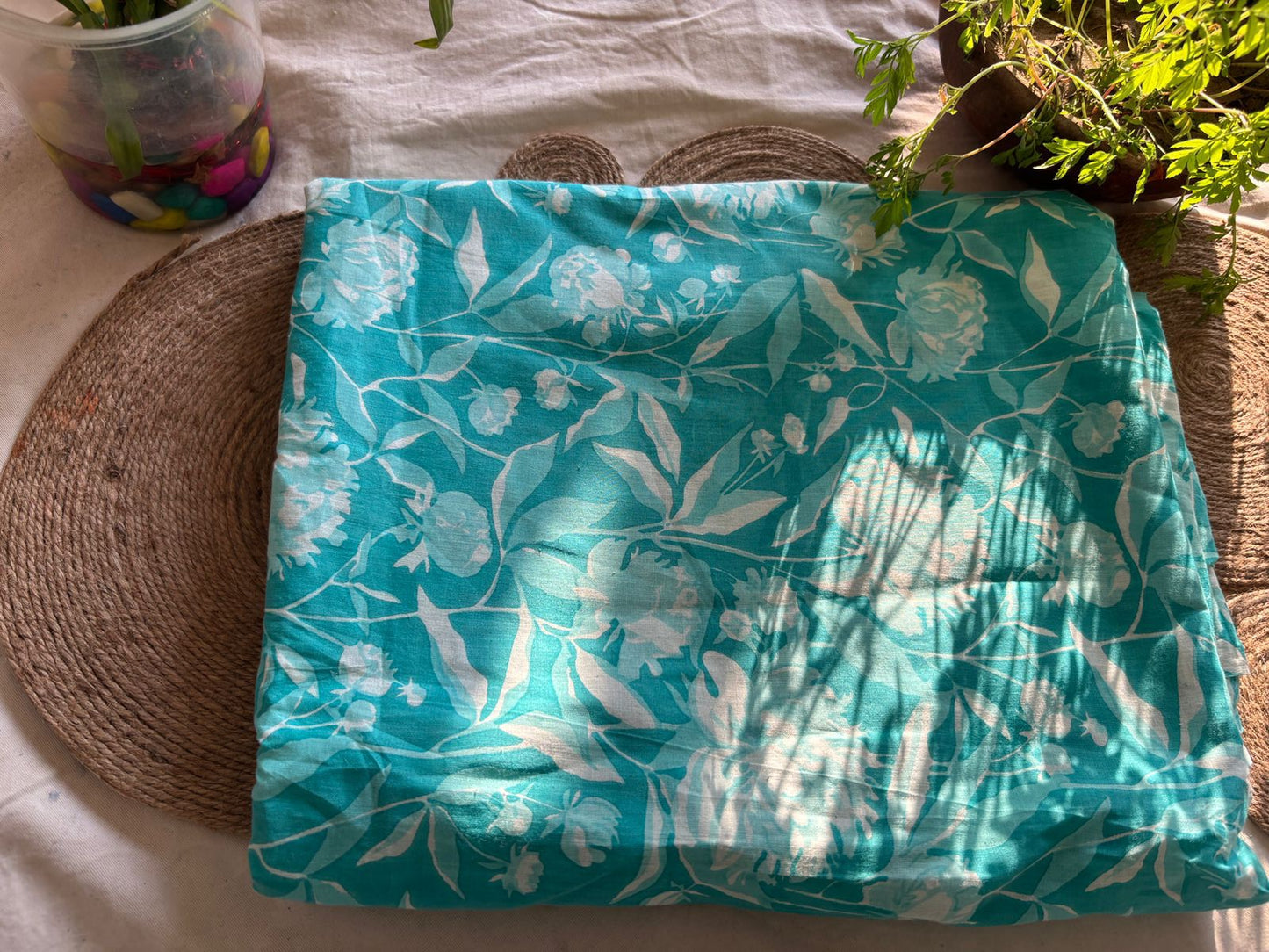 Turquoise-colored fabric with a white floral print